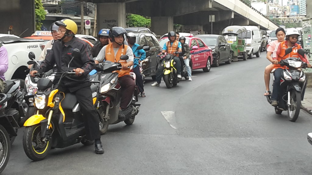 The drivers with orange vests are motorbike taxis